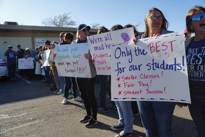 Snowline employees are poised to cheer as the Snowline Board of Trustees arrive at a recent board meeting.