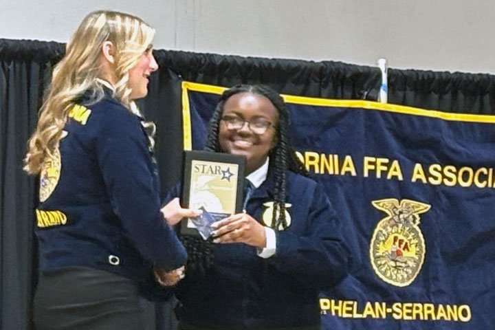 President Mia Johnson (Left) awards Chloe Westerkamp the Start Chapter Farmer award.