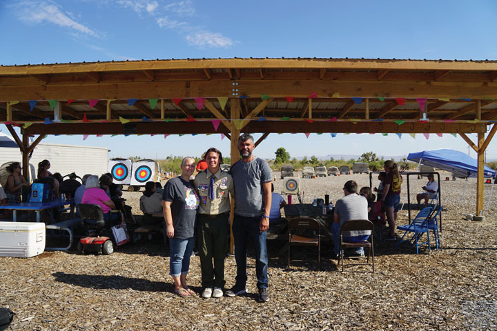 Richard standing in front of his Eagle Scout accomplishment between his proud parents.
