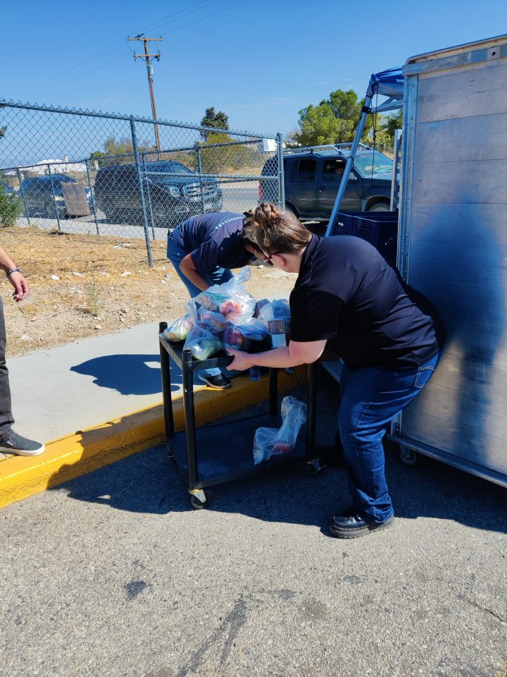 Snowline Nutrition Workers preparing the proper amount of meals per child to deliver to the cars patiently waiting in line.