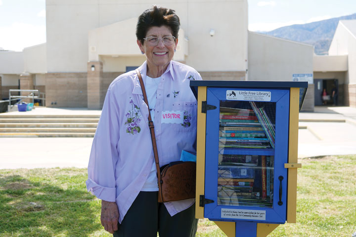 Diana Ford is pictured with the latest installation of the Little Free Library.  This little library was dedicated to. her by the Tri-Community Kiwanis in small ceremony at Pinon Hills Elementary School.