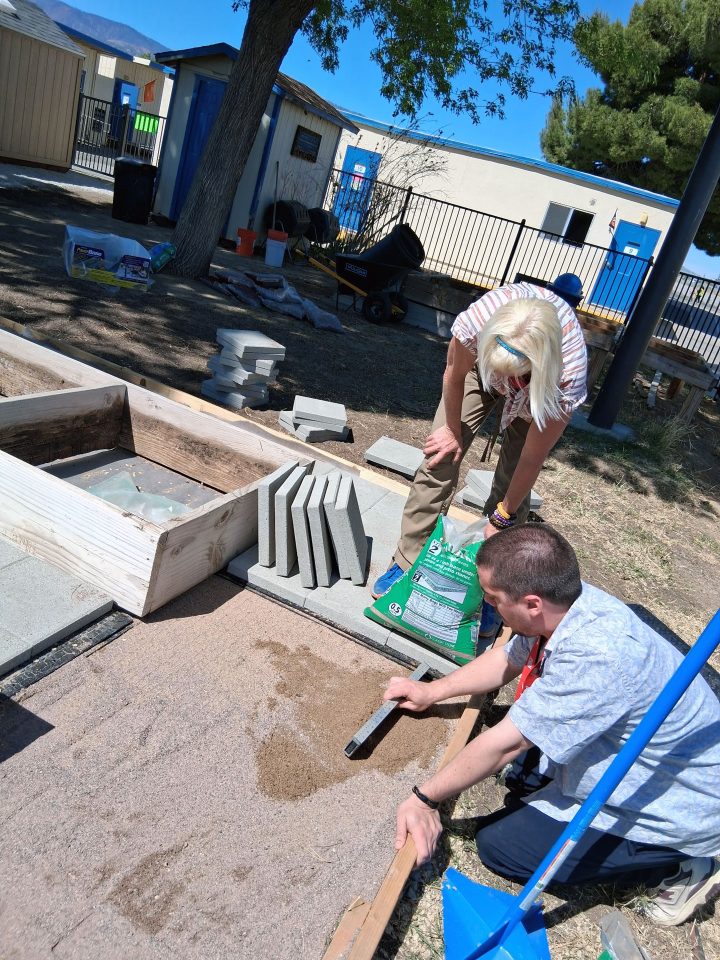 Teacher volunteering to place pavers in the newly renovated Phelan Elementary School garden.