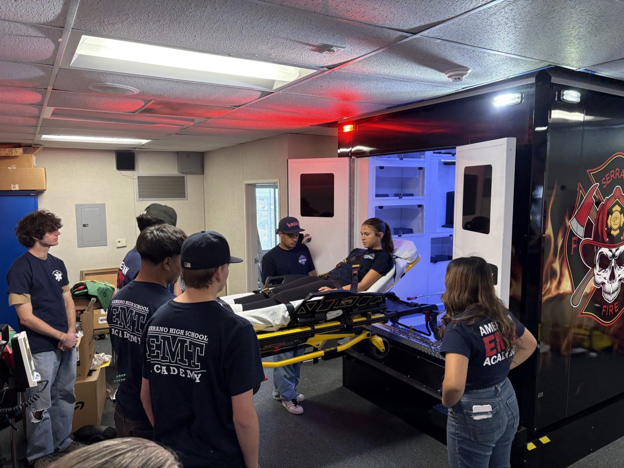 Here, students in the new EMT class use their new ambulance simulator.