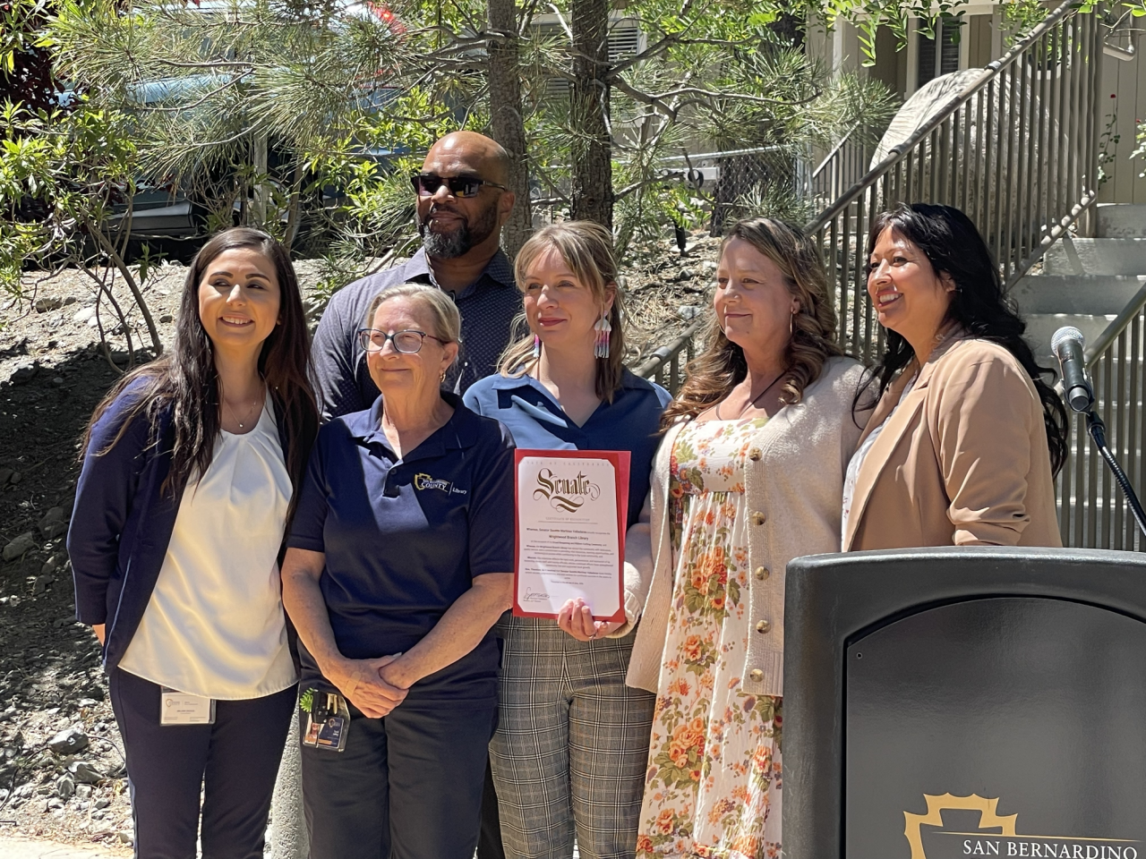 Representatives from Senator Suzette Valladares' office presents the library staff with certificate of recognition.